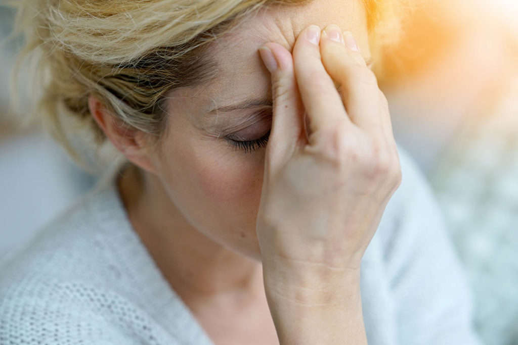 a person holds their heard possibly struggling with opiate withdrawal symptoms