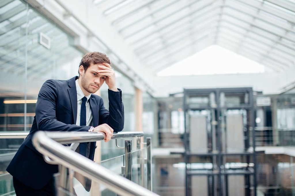 a businessperson stares down steps possibly struggling with binge drinking